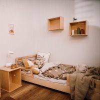 Montessori floor bed with lateral protection in a setting