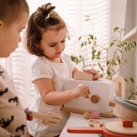 Toaster with 2 slices of bread in a setting with children